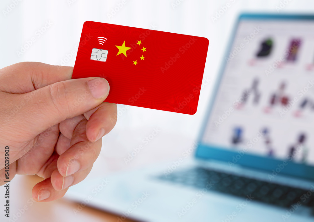 Hands holding plastic credit card and using laptop. Online shopping concept in China