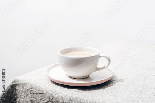 A cup of coffee on a table with tablecloth. Minimal still life. Closeup