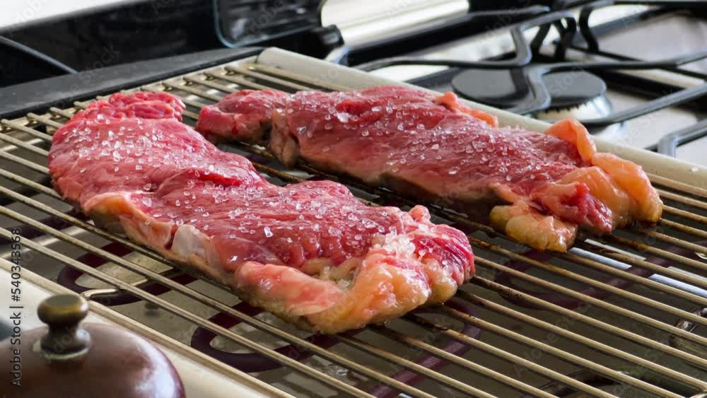 Preparing Ribeye Raw Steaks on Eletric Grill, Sunday Lunch in the Kitchen Preparing Ribeye Raw Steaks on Eletric Grill, Sunday Lunch in the Kitchen