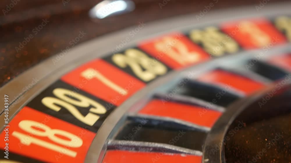 Ball on wooden french roulette table in casino. Wheel spinning, turning or rotating. Odd and even numbers, black, red and zero sectors. Bets in game of chance. Money playing, gambling or risky betting