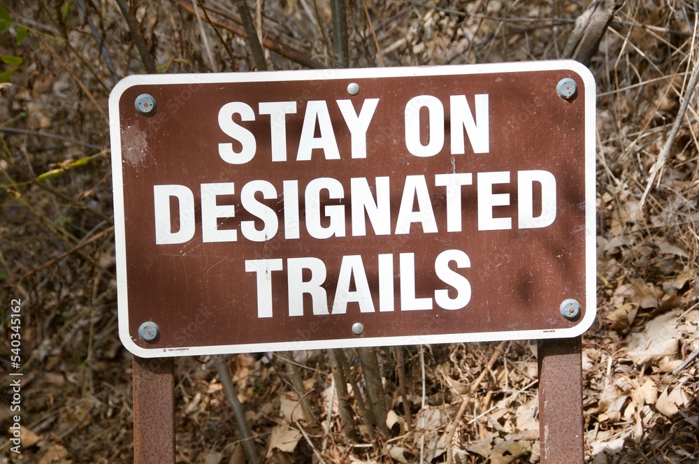 Stay on designated trails sign at beginning of trail head Corral canyon park Malibu California Stay on designated trails sign at beginning of trail head Corral canyon park Malibu California