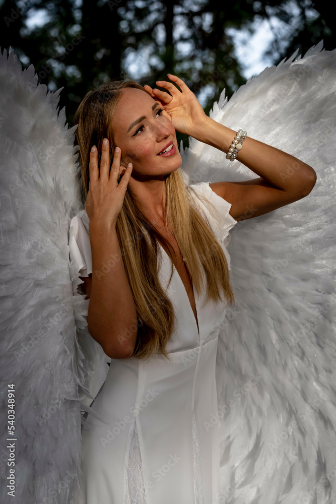 A Lovely Blonde Model Poses Outdoors While Wearing White Handmade Wings For Halloween A Lovely Blonde Model Poses Outdoors While Wearing White Handmade Wings For Halloween