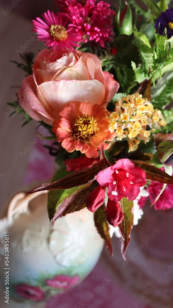 Obraz premium A bouquet of autumn flowers in a decorated porcelain vase in a still life.