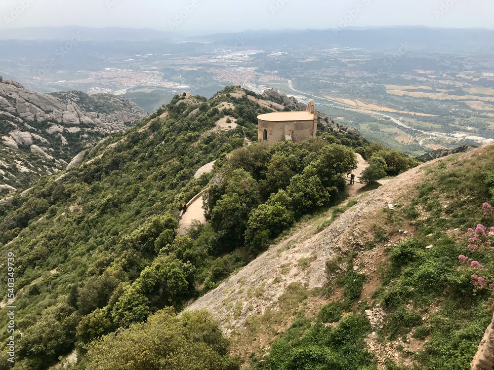 Montserrat, Spain, June 2019 - A view of a rocky mountain with Nimrod Fortress in the background