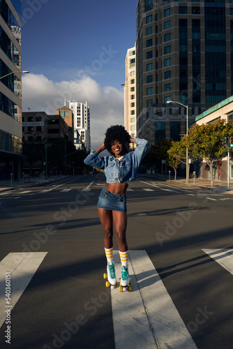 Portrait of young beautiful women with afro hair in the city with rolllerskates