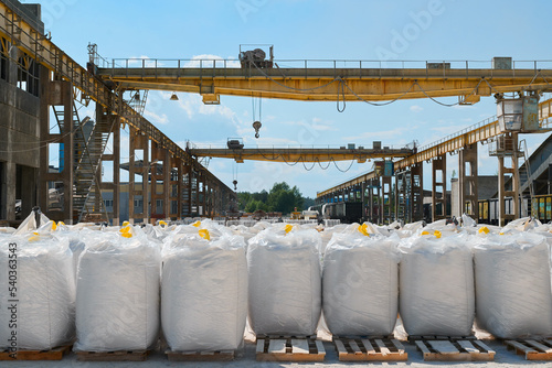 Big bags with calcium carbonate in yard of production plant photo