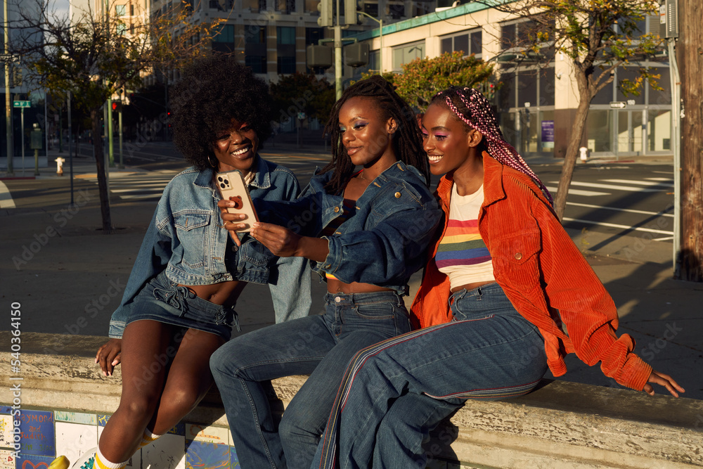 Fototapeta premium Portrait of young friend group together in the city on the phone taking selfies 