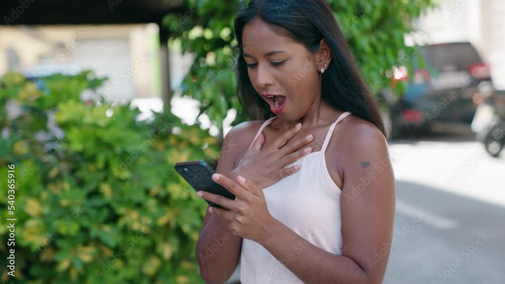 Young beautiful woman using smartphone with winner expression at street Young beautiful woman using smartphone with winner expression at street
