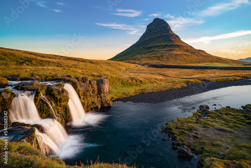 Kirkjufell mountain in golden sunrise with falls