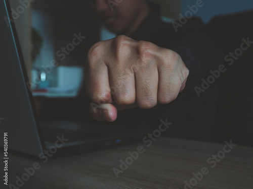 fist punching forward young businessman who is struggling with problems