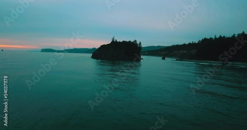 Aerial Forward Tilt Up Shot Of Natural Rock In Wavy Sea During Sunset - Siuslaw National Forest, Oregon photo