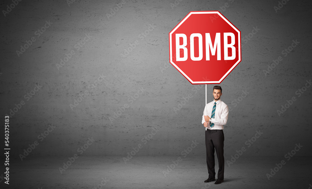 Obraz premium Young business person holding road sign