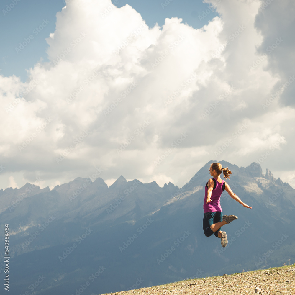 Young woman jumping on the top of the mountains