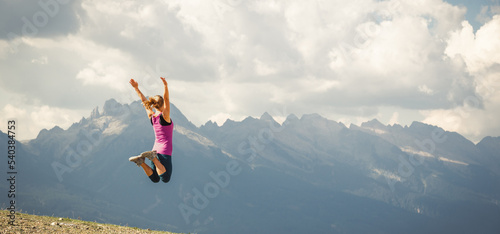 Young woman jumping on the top of the mountains
