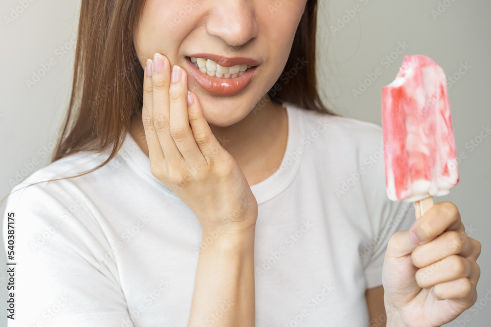 Face expression suffering from sensitive teeth and cold, asian young woman, girl hand touching