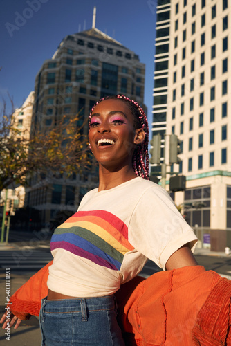 Portrait of young non-conforming with braids smiling in the city