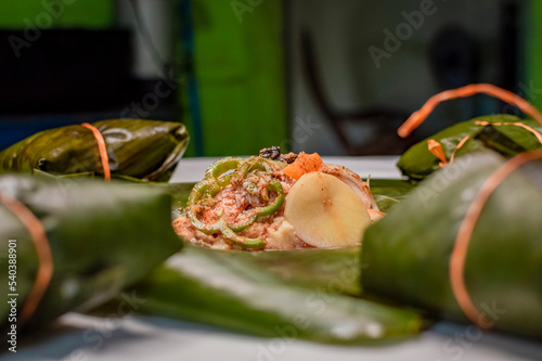 Preparation of the traditional Nacatamal, closeup of raw ingredients for the elaboration of a Nicaraguan nacatamal. Nacatamal ingredients on banana leaves photo