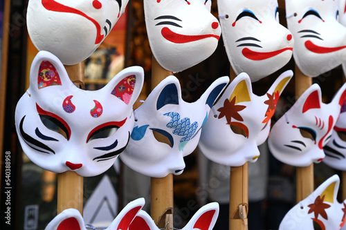 日本のお祭りで狐と猫のお面が並ぶ風景