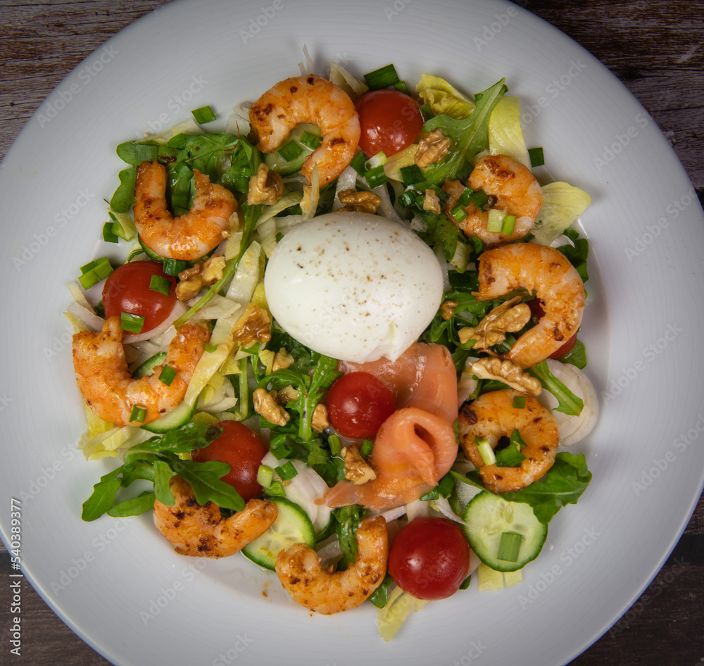 Recipe for rocket salad, endive, tomato, cucumber, soft-boiled egg, fried shrimp with paprika, smoked salmon and nuts. High quality photo Recipe for rocket salad, endive, tomato, cucumber, soft-boiled egg, fried shrimp with paprika, smoked salmon and nuts. High quality photo
