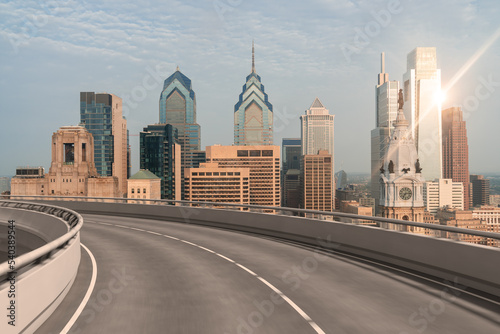 Empty urban asphalt road exterior with city buildings background. New modern highway concrete construction. Concept way to success. Transportation logistic industry fast delivery. Philadelphia. USA.