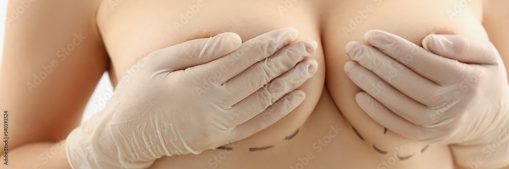 Woman hold breasts and cover with hands, natural size of boobs