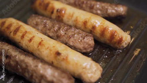 Sausages fried in a frying pan grill footage slow motion