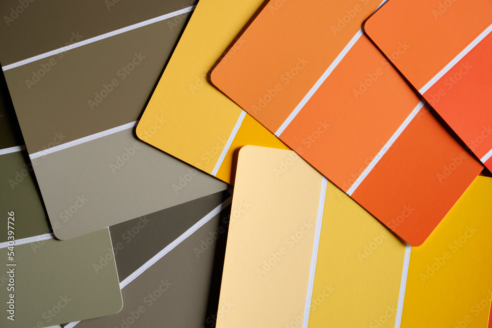 Orange yellow and green color swatches scattered on a table. Generic ...