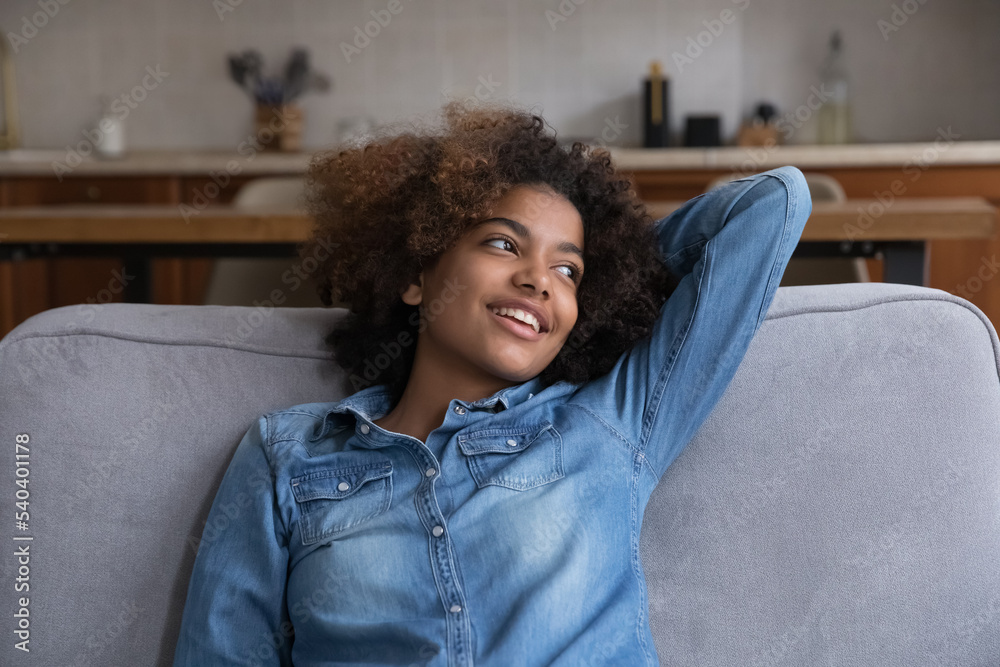Φωτογραφία Beautiful untroubled curly-haired African teenager girl relaxing alone leaned on
