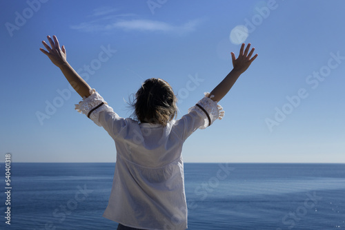 a happy young woman enjoying freedom with her hands open at sea. High quality photo