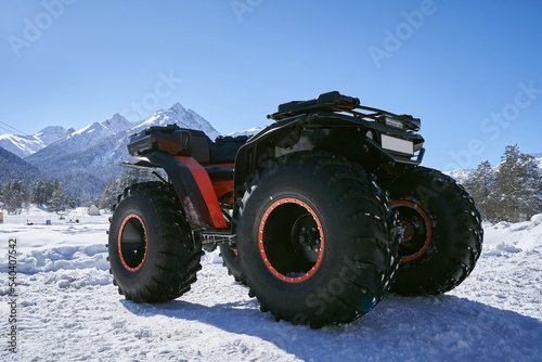 Quad bike with big wheels on the snow in mountains