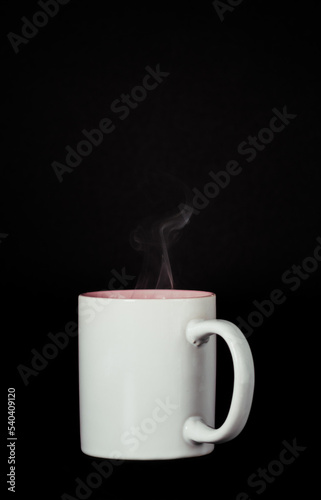 steaming white coffee cup on black background