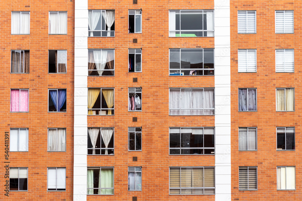 Building facade with many windows and curtains. The building is made of bricks. Beautiful geometric composition, Bogota, Colombia.