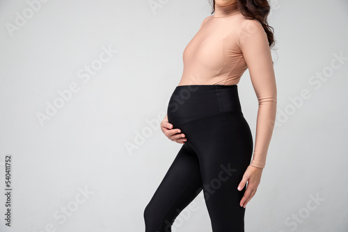 Clothes for pregnant, black pants with high waist isolated on white background, pregnancy concept.leggings for pregnant women, black tights.Special elastic band for the abdomen.
