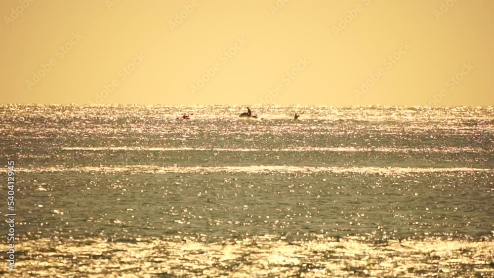 Abstract sea summer ocean sunset nature background. Small waves on azure water surface in motion blur with golden bokeh lights from sun. Holiday, vacation and recreational concept. Slow motion
