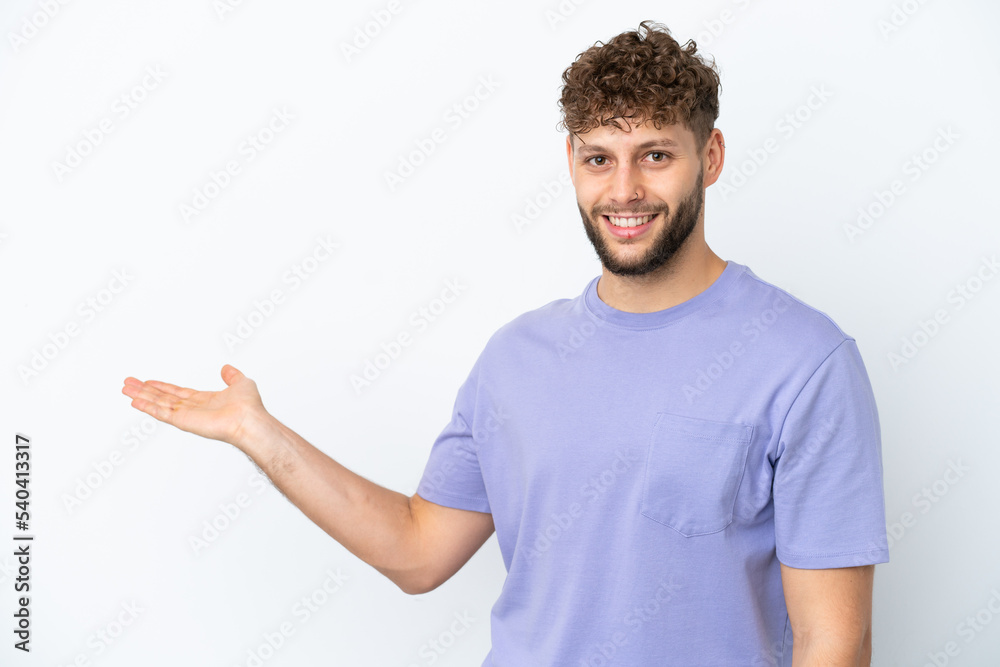 Young handsome caucasian man isolated on white background extending hands to the side for inviting to come Young handsome caucasian man isolated on white background extending hands to the side for inviting to come