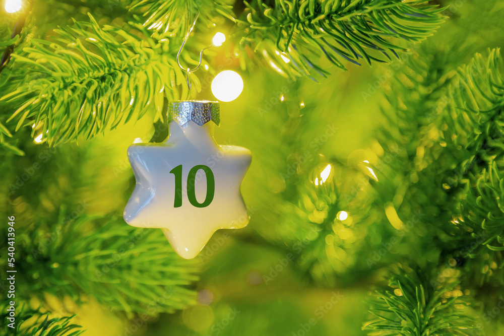 ein Weihnachtsstern mit einer Zahl (10) am Weihnachtsbaum