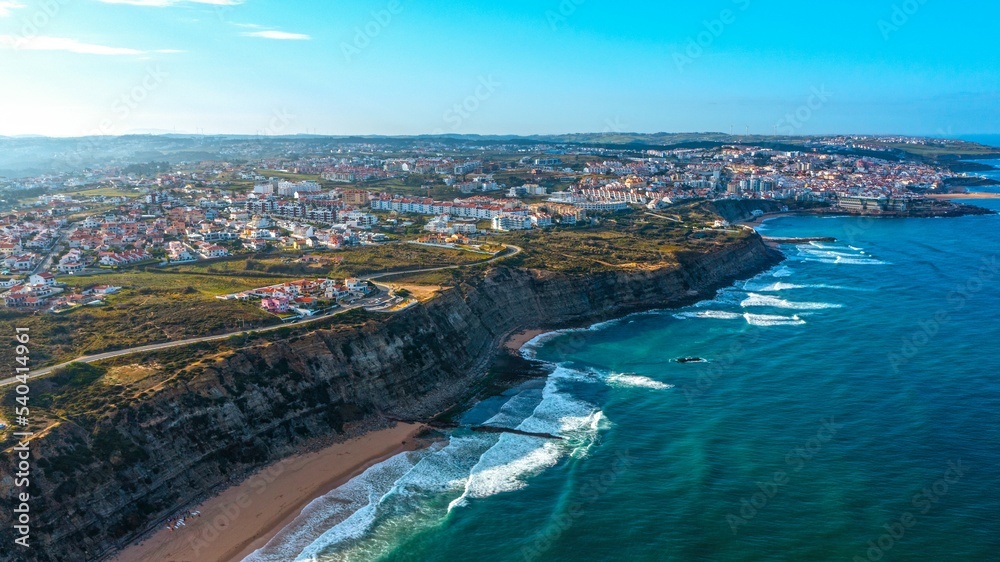 Drone aerial view over beaches and  rocky coastline in  Portugal, during sunset. Aerial view to the Beautiful European touristic town. Beautiful cityscape with skyline, ocean rocky shore. Travel place
