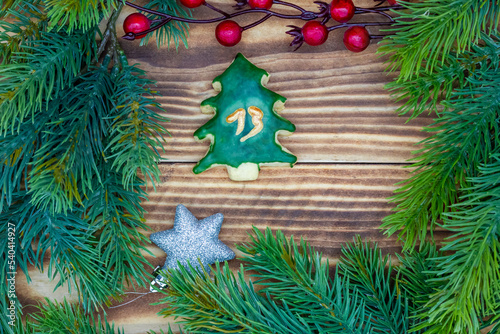 leckeres Plätzchen mit einer Zahl (13) auf weihnachtlichen Hintergrund aus Holz