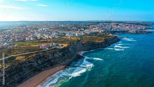 Drone aerial view over beaches and  rocky coastline in  Portugal, during sunset. Aerial view to the Beautiful European touristic town. Beautiful cityscape with skyline, ocean rocky shore. Travel place © Valua Vitaly