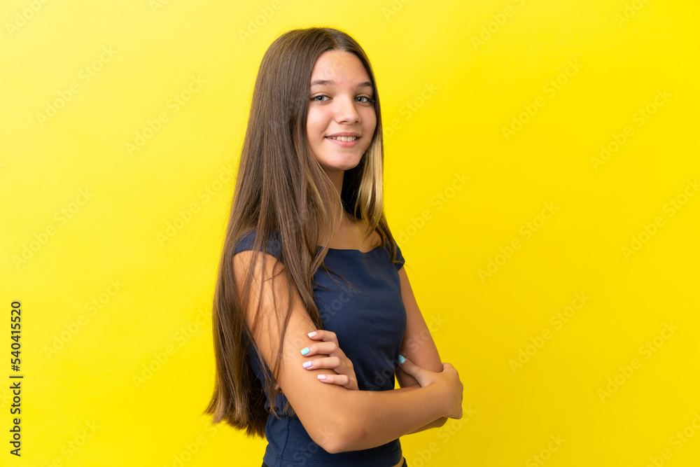 Little caucasian girl isolated on yellow background with arms crossed and looking forward Little caucasian girl isolated on yellow background with arms crossed and looking forward