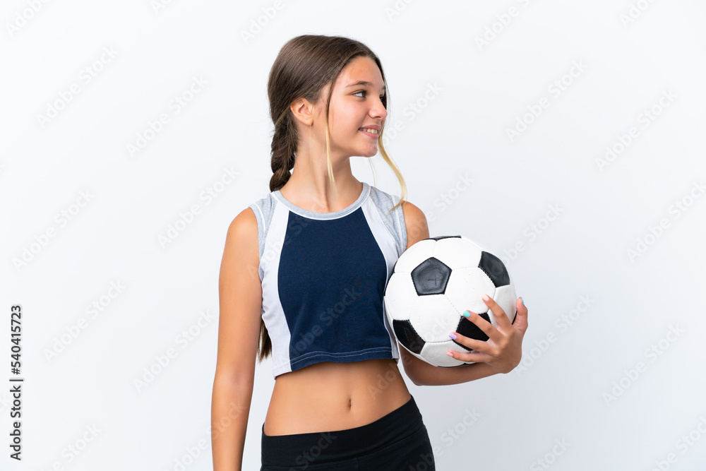 Little caucasian girl playing football isolated on white background looking side Little caucasian girl playing football isolated on white background looking side