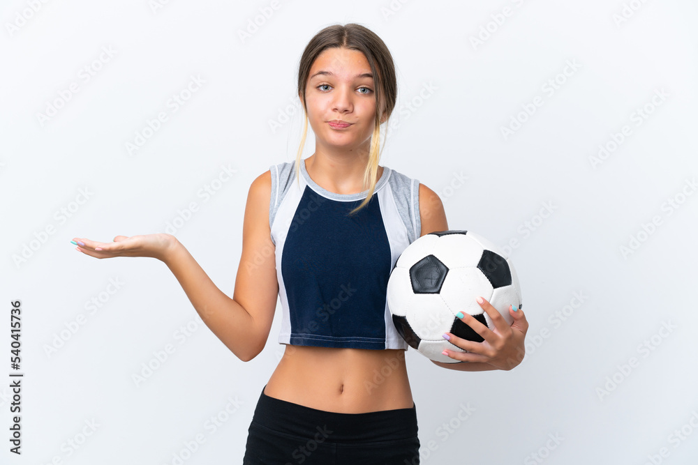 Little caucasian girl playing football isolated on white background having doubts while raising hands Little caucasian girl playing football isolated on white background having doubts while raising hands
