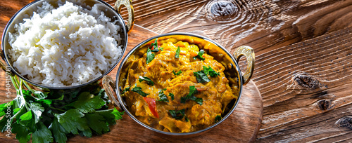 Curry chicken with rice served in original indian karahi pots photo