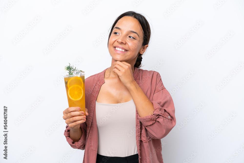 Young hispanic woman holding a cocktail isolated on white background looking up while smiling Young hispanic woman holding a cocktail isolated on white background looking up while smiling