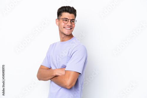 Young caucasian man isolated on white background with arms crossed and happy