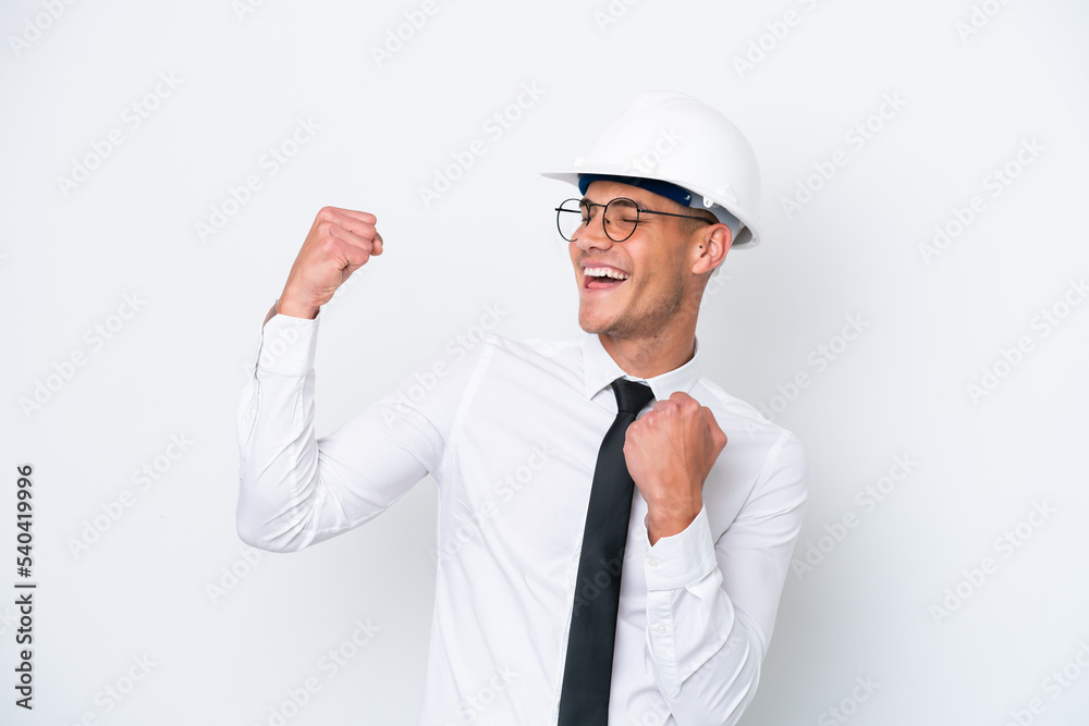 Young architect caucasian man with helmet and holding blueprints isolated on white background celebrating a victory Young architect caucasian man with helmet and holding blueprints isolated on white background celebrating a victory
