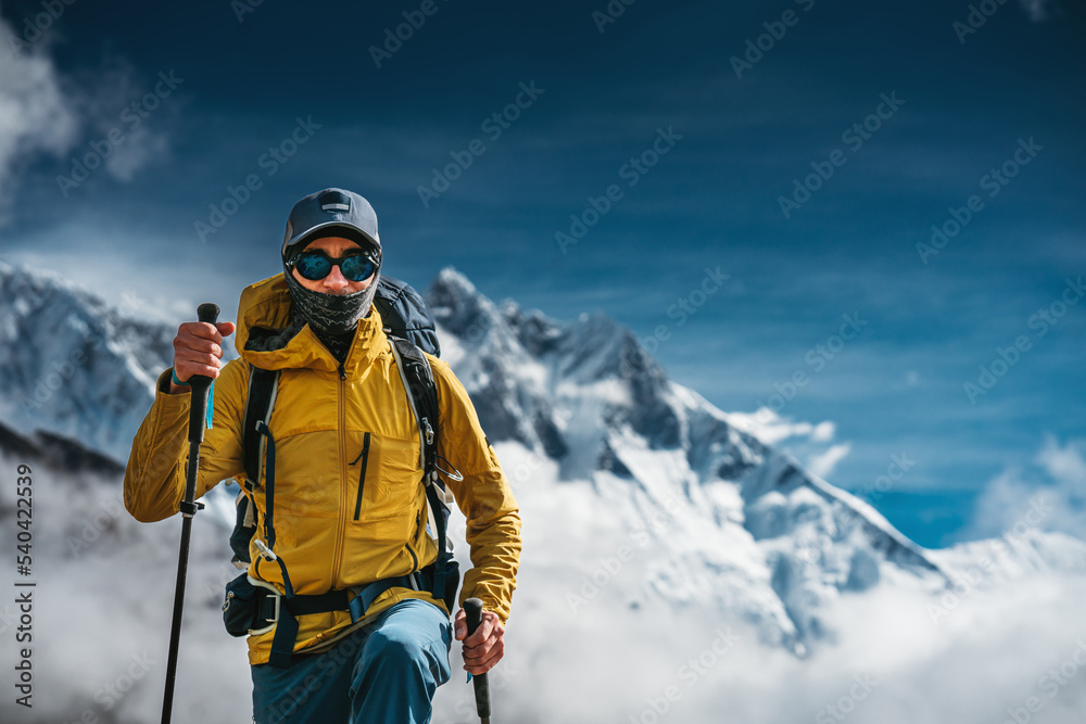 Solo brave traveler walk to mountain summit wearing professional travel equipment. Yong hiker traveling across mountain track among high altitude sunny rok