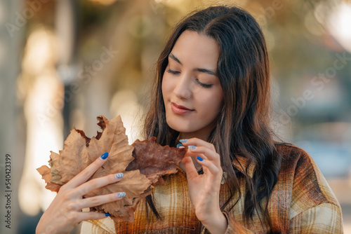 portrait of young millennial girl on the street outdoors with autumn leaves