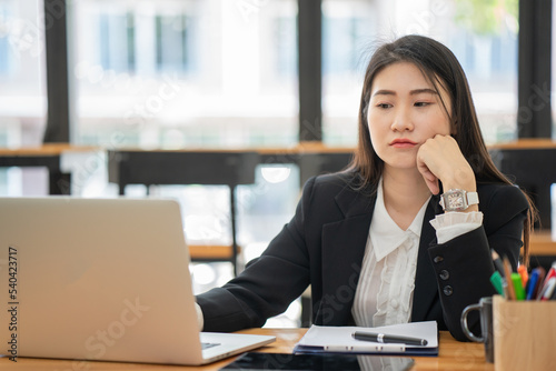 Frustrated Asian beautiful businesswoman feeling depressed, exhausted, tired, and lazy during working at the office.