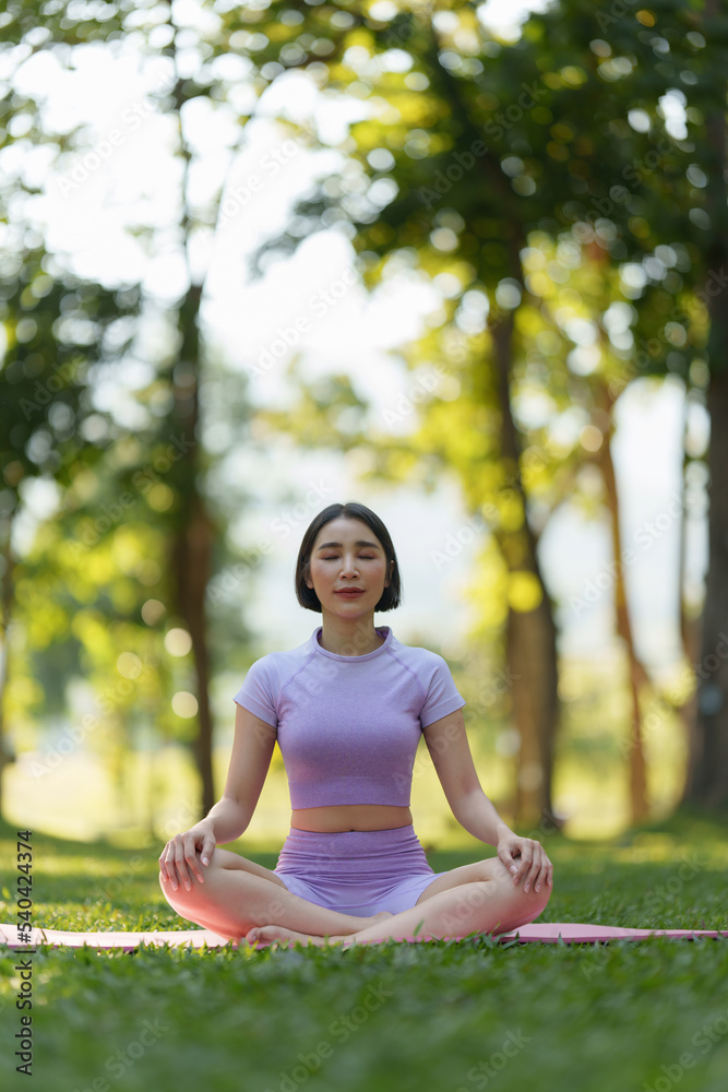 Attractive Asian woman in sportswear practicing yoga in the outdoor park Attractive Asian woman in sportswear practicing yoga in the outdoor park